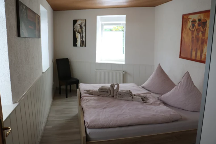 Schlafzimmer mit Doppelbett und Sitzgelegenheit